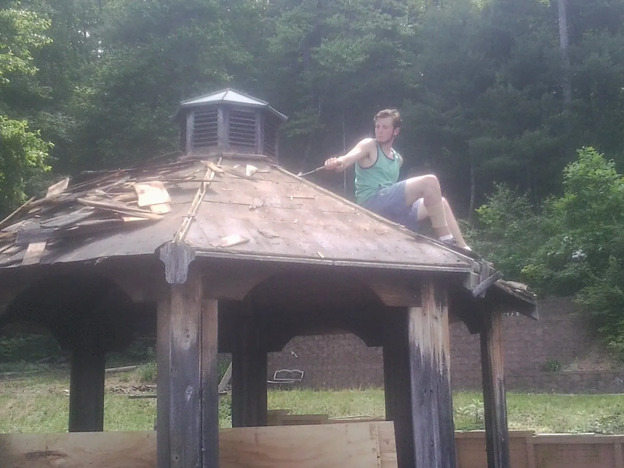 Tearing the old roof off a wooden gazebo before new shakes in Kingston